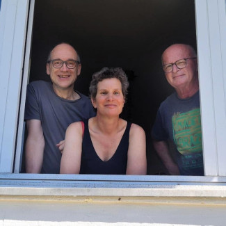 Thomas Weinmair, Dr. Ulrike Kuschel und Günther Schindler lächeln aus einem Fenster